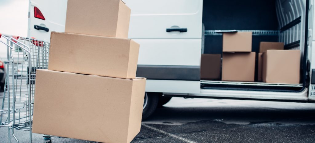 Trolley with cardboard boxes against mail van